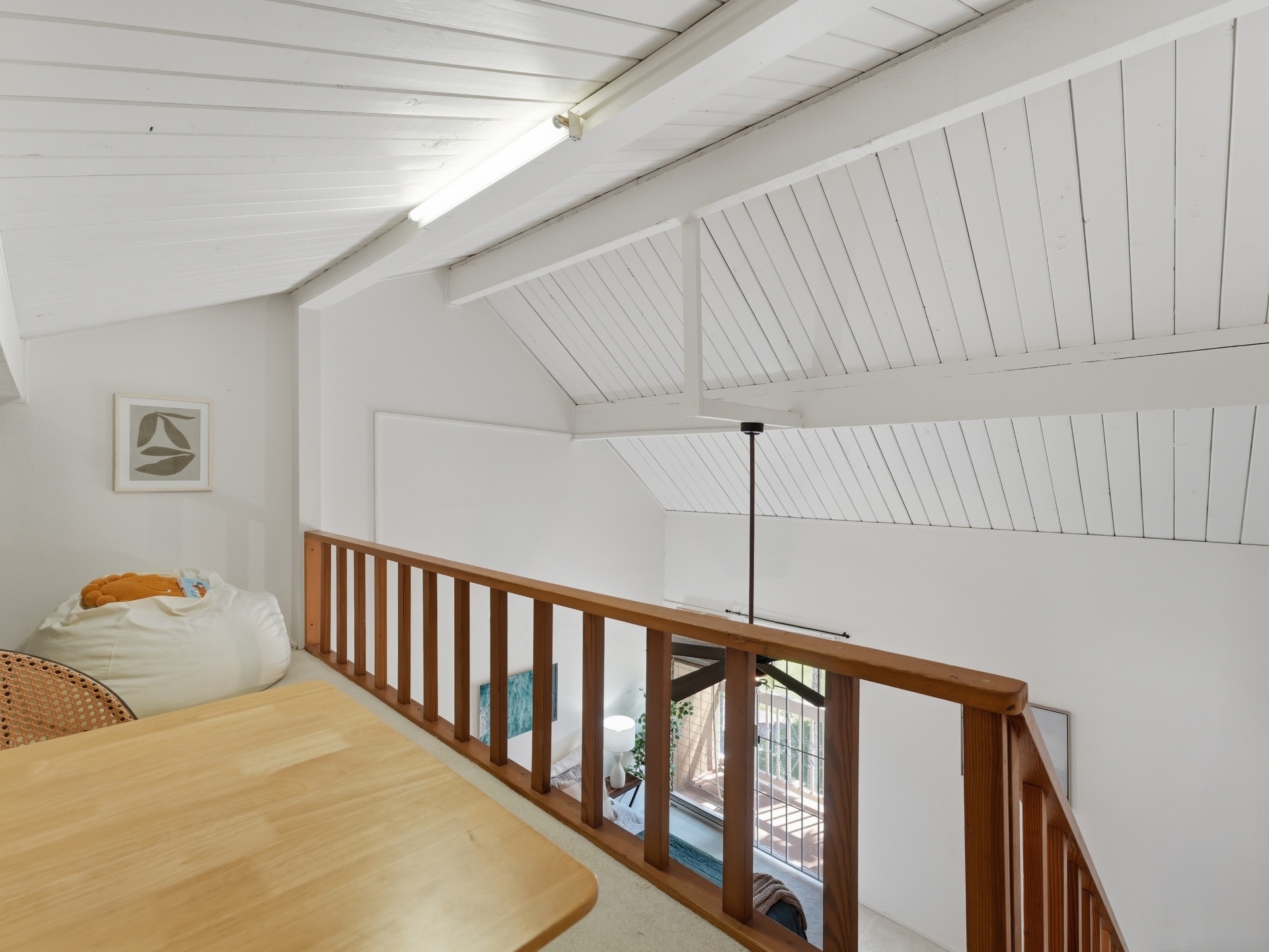 Loft view down to bedroom through wood railing