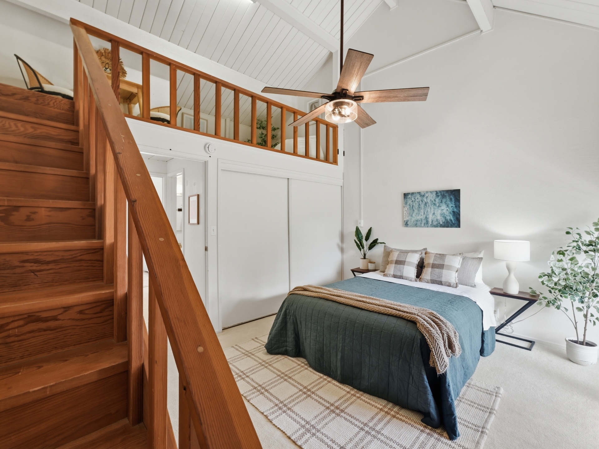 Primary bedroom with vaulted ceilings, loft above and staircase