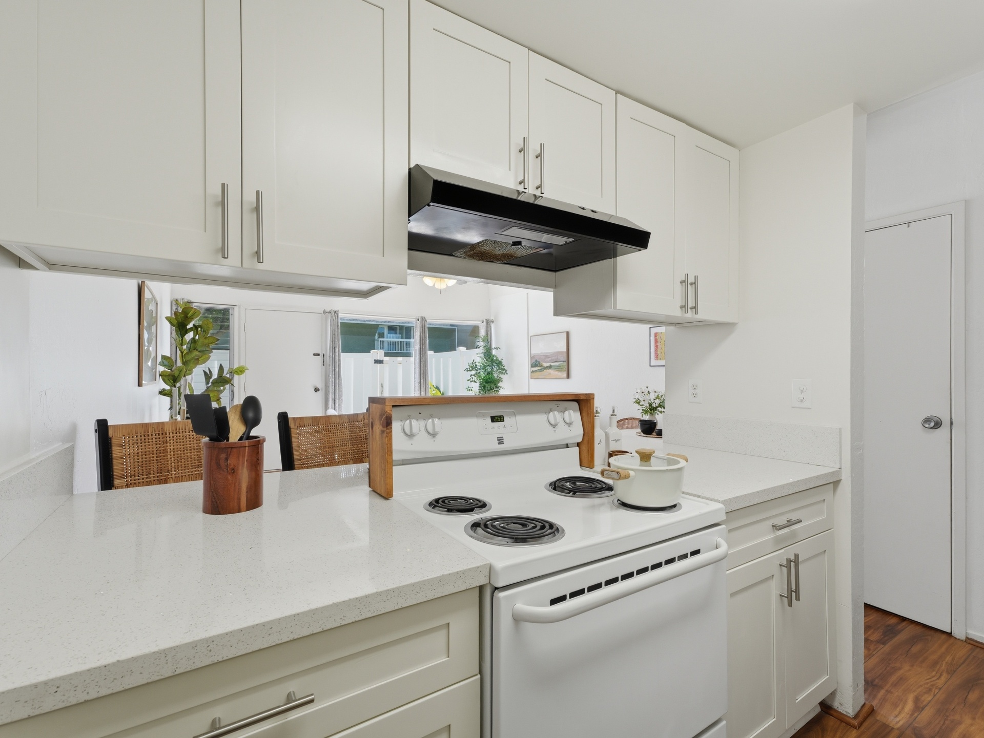 Updated kitchen with quartz countertops, white shaker cabinets and range
