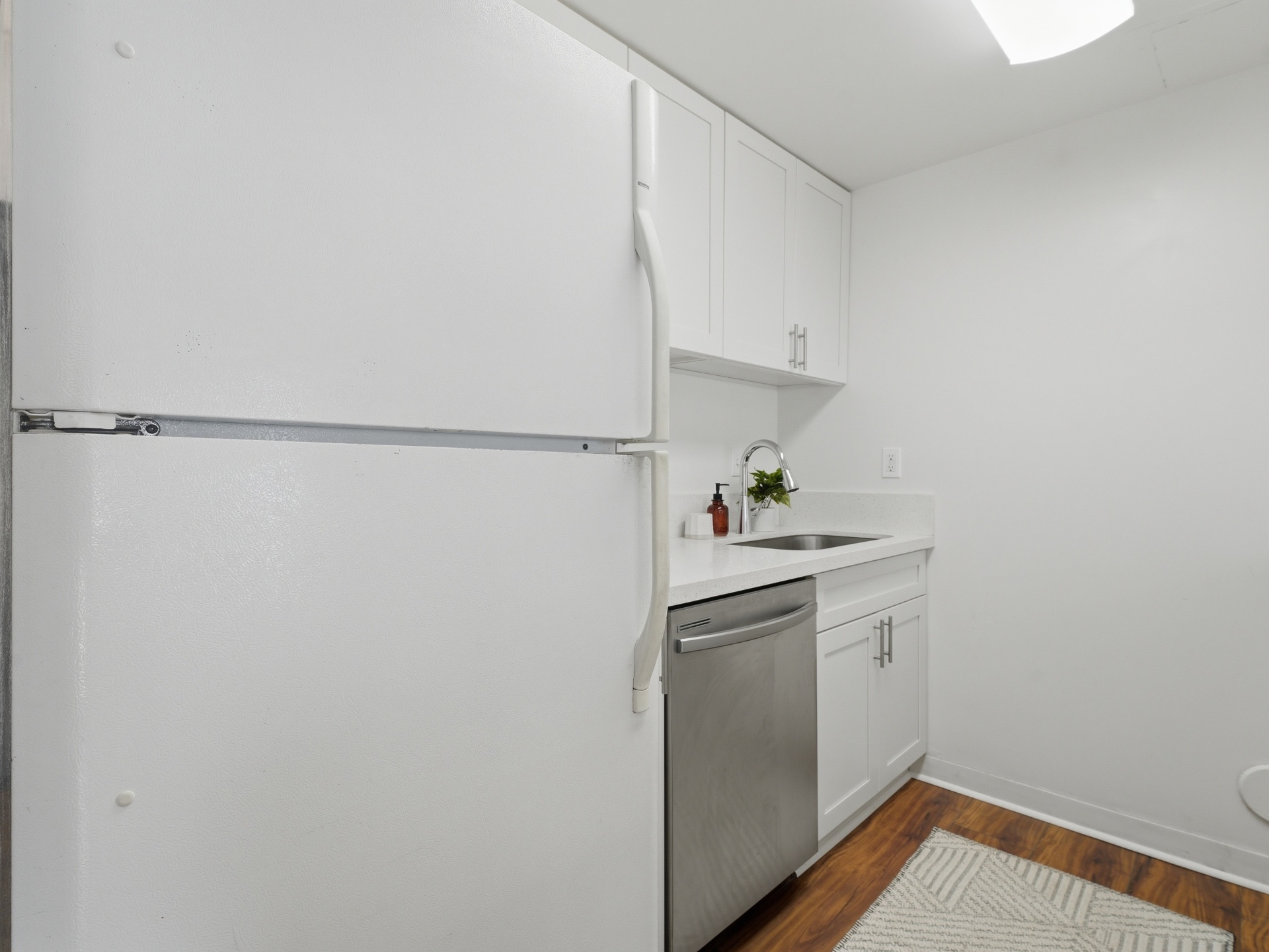 Kitchen with refrigerator, stainless dishwasher and quartz sink area