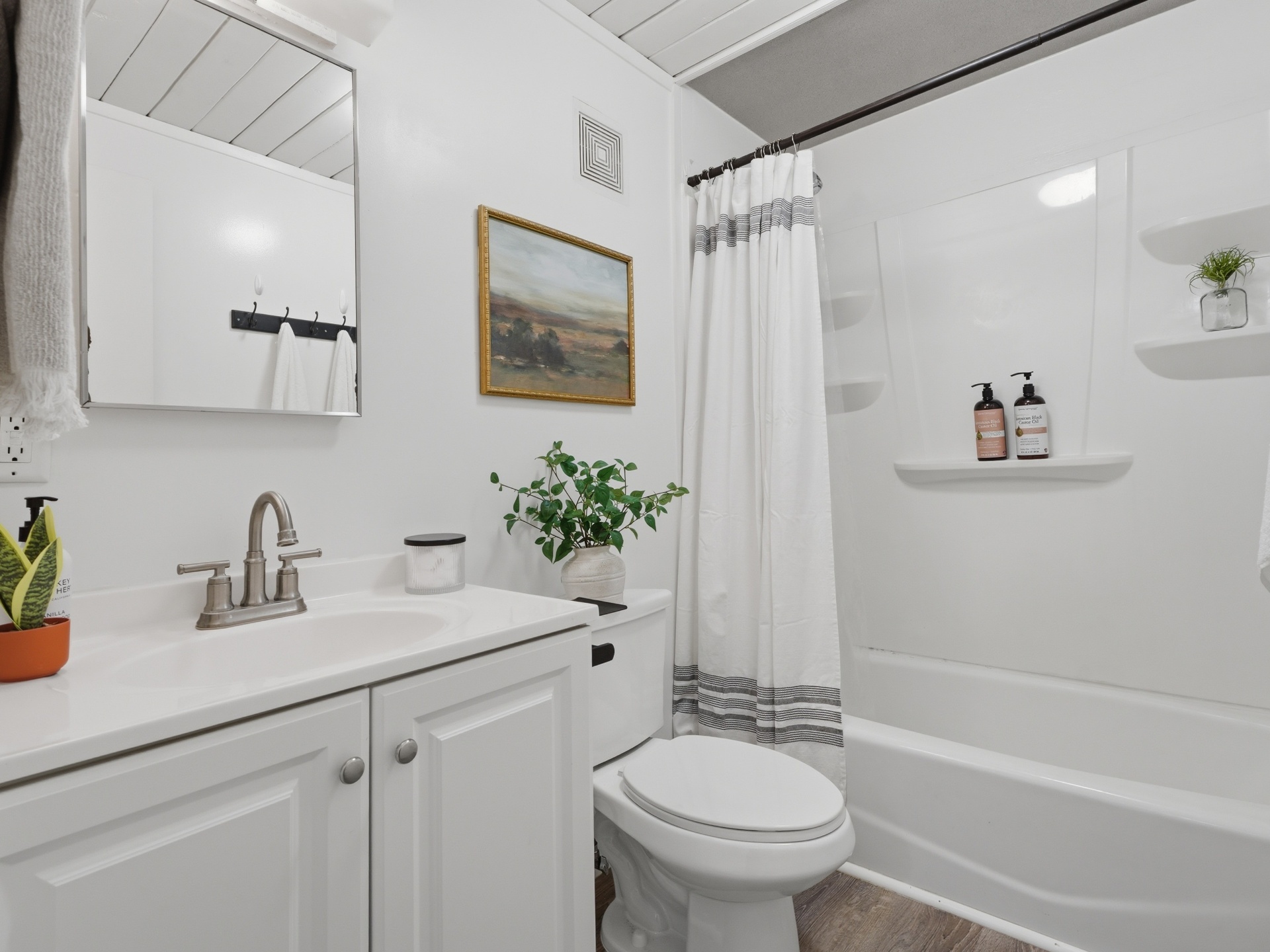 Refreshed full bathroom with white vanity, tub and shower