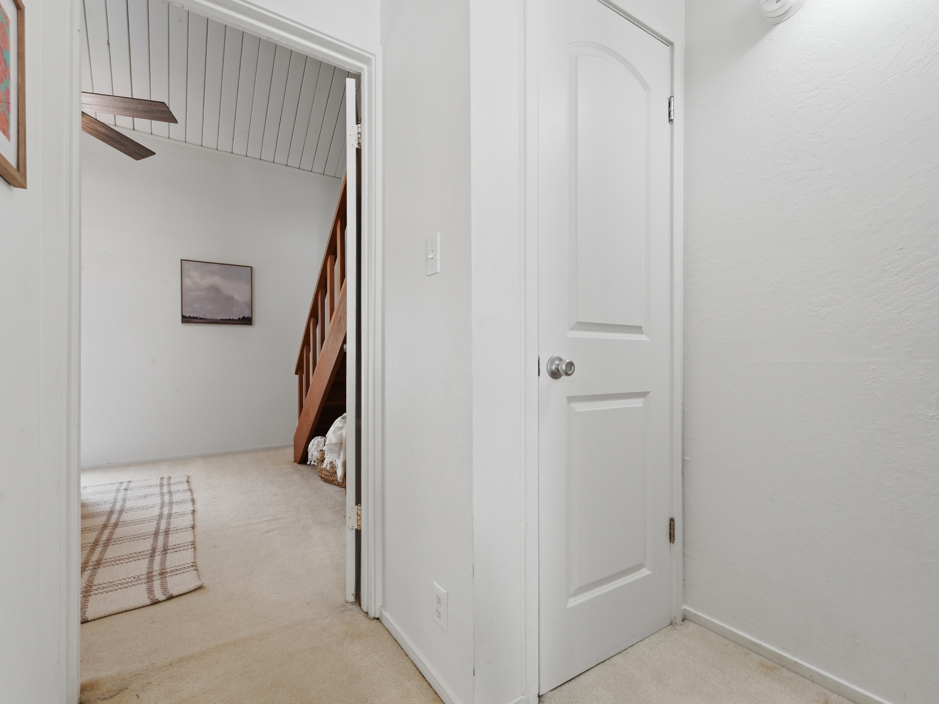 Hallway with bedroom doorway and staircase to loft beyond