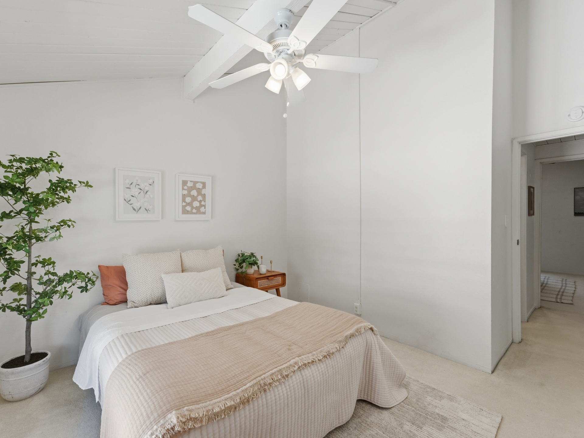 Second bedroom showing vaulted beam ceiling and hallway view