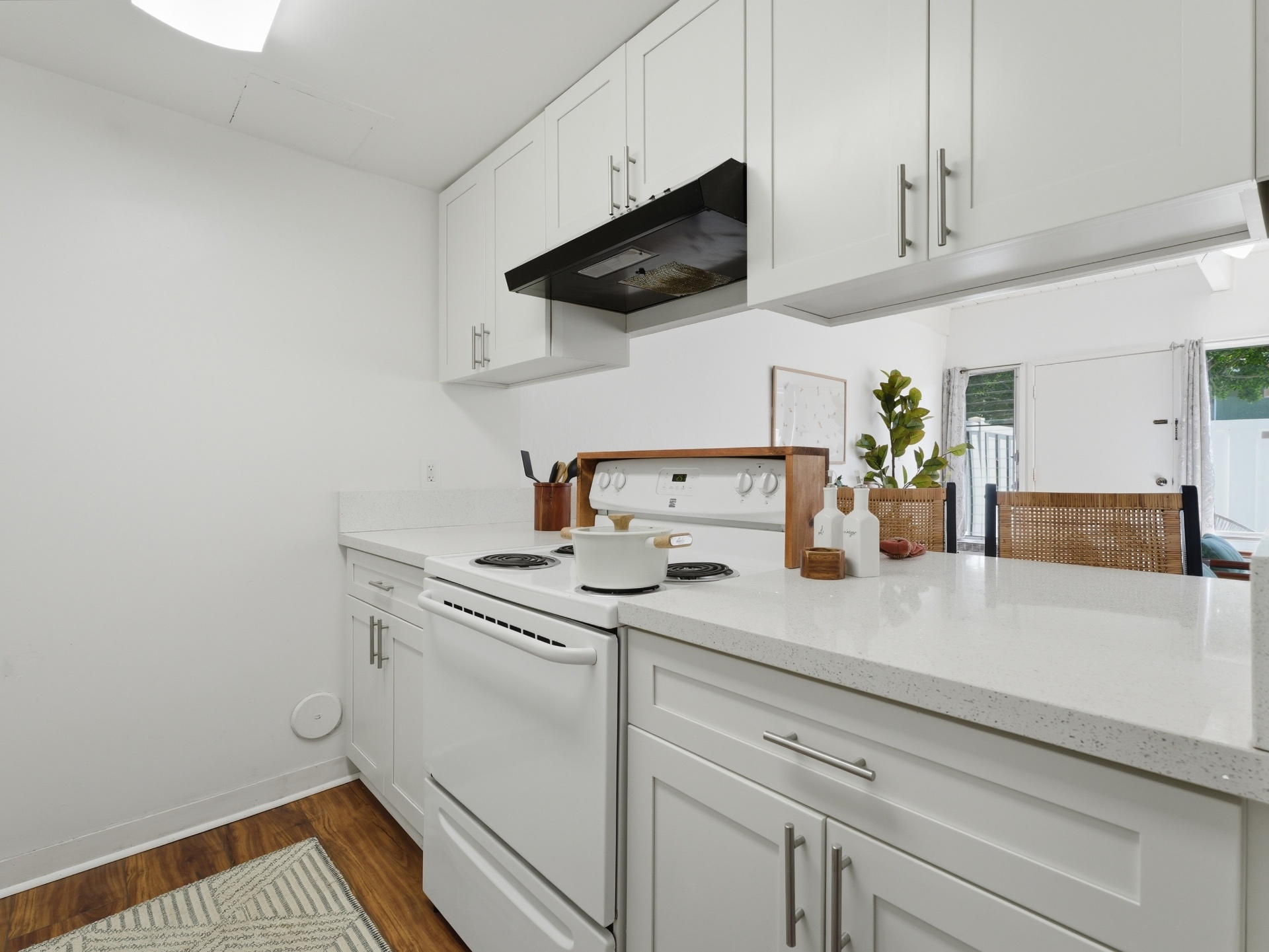 Kitchen showing range, quartz counters and pass-through to dining