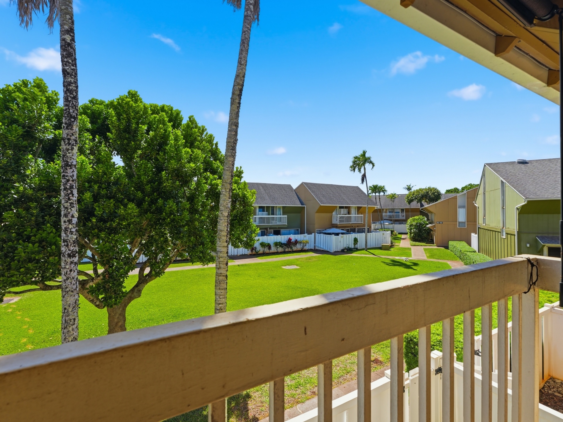 Lanai view overlooking expansive grassy courtyard and neighboring townhomes