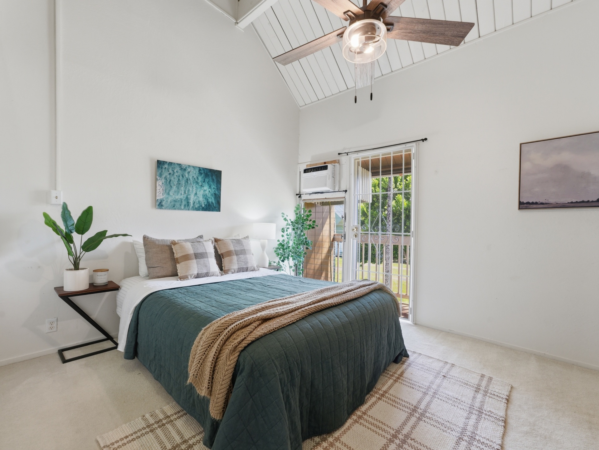 Bright bedroom with high ceilings, ceiling fan and lanai door