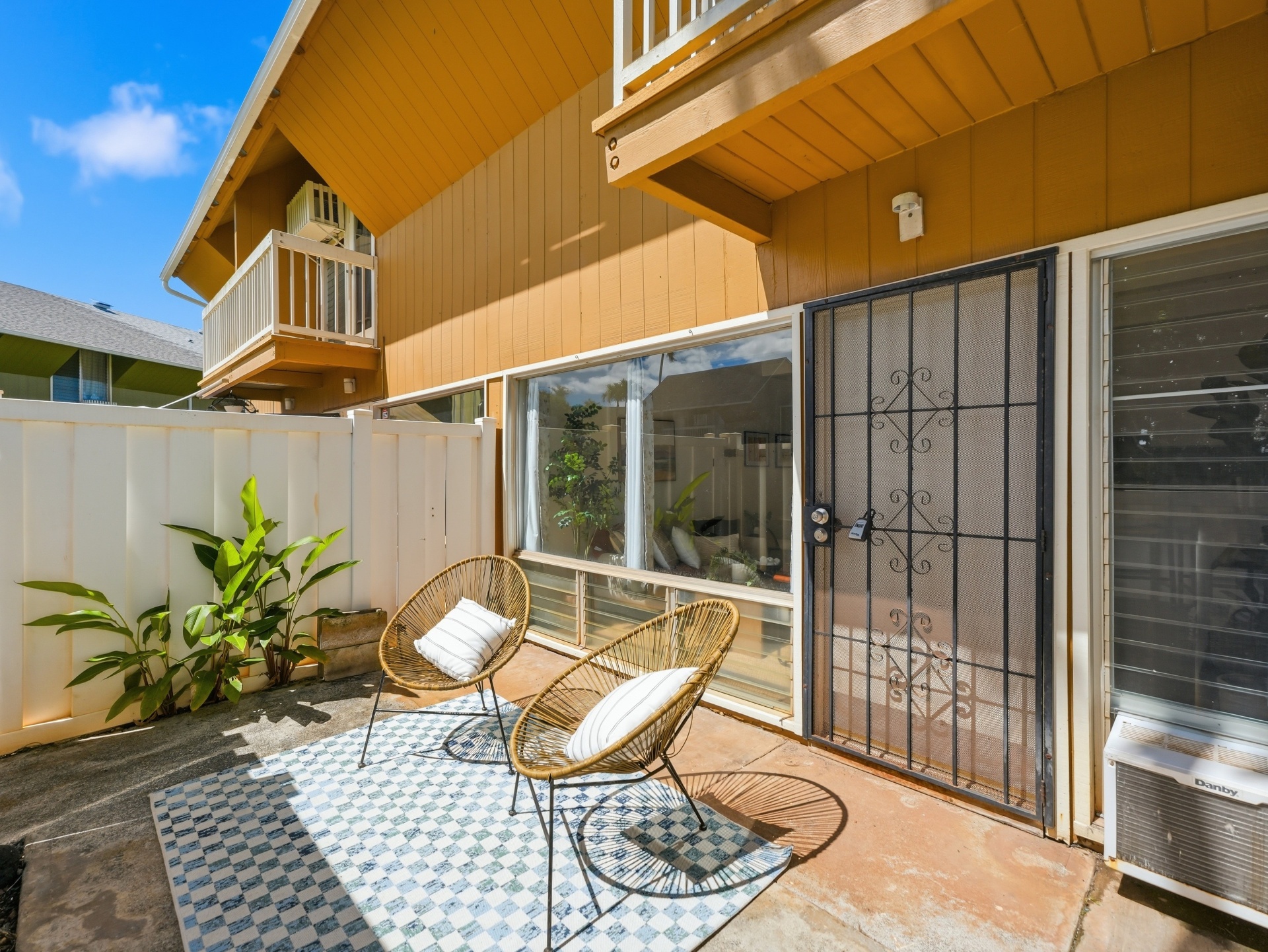 Sunny courtyard patio with seating area and entry door